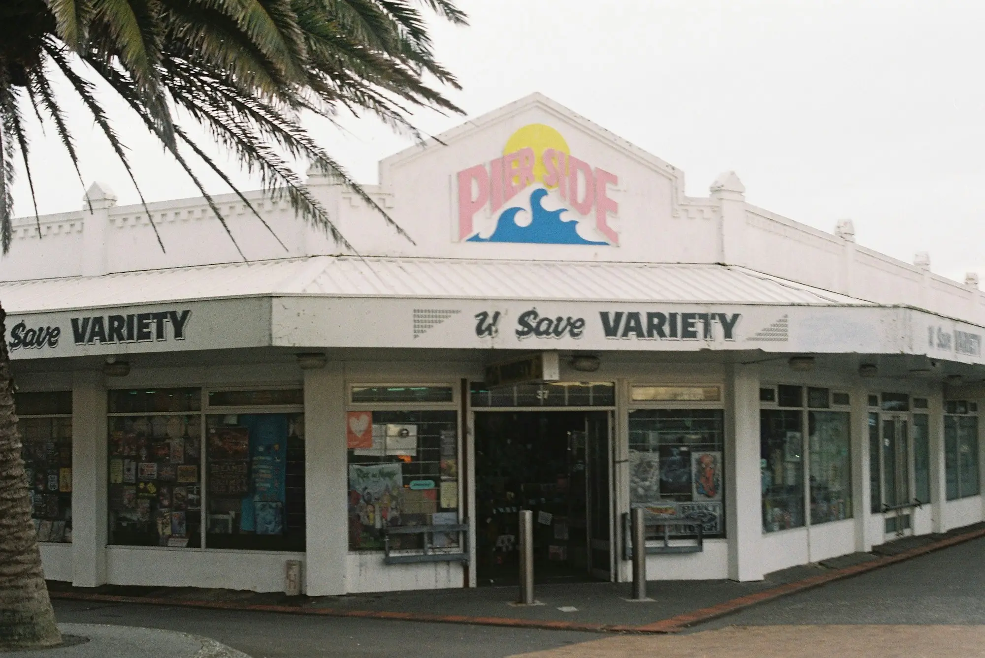 Corner variety store in an old parapet-fronted building with a palm tree out front, the kind of freehold premises a business owner might want to buy