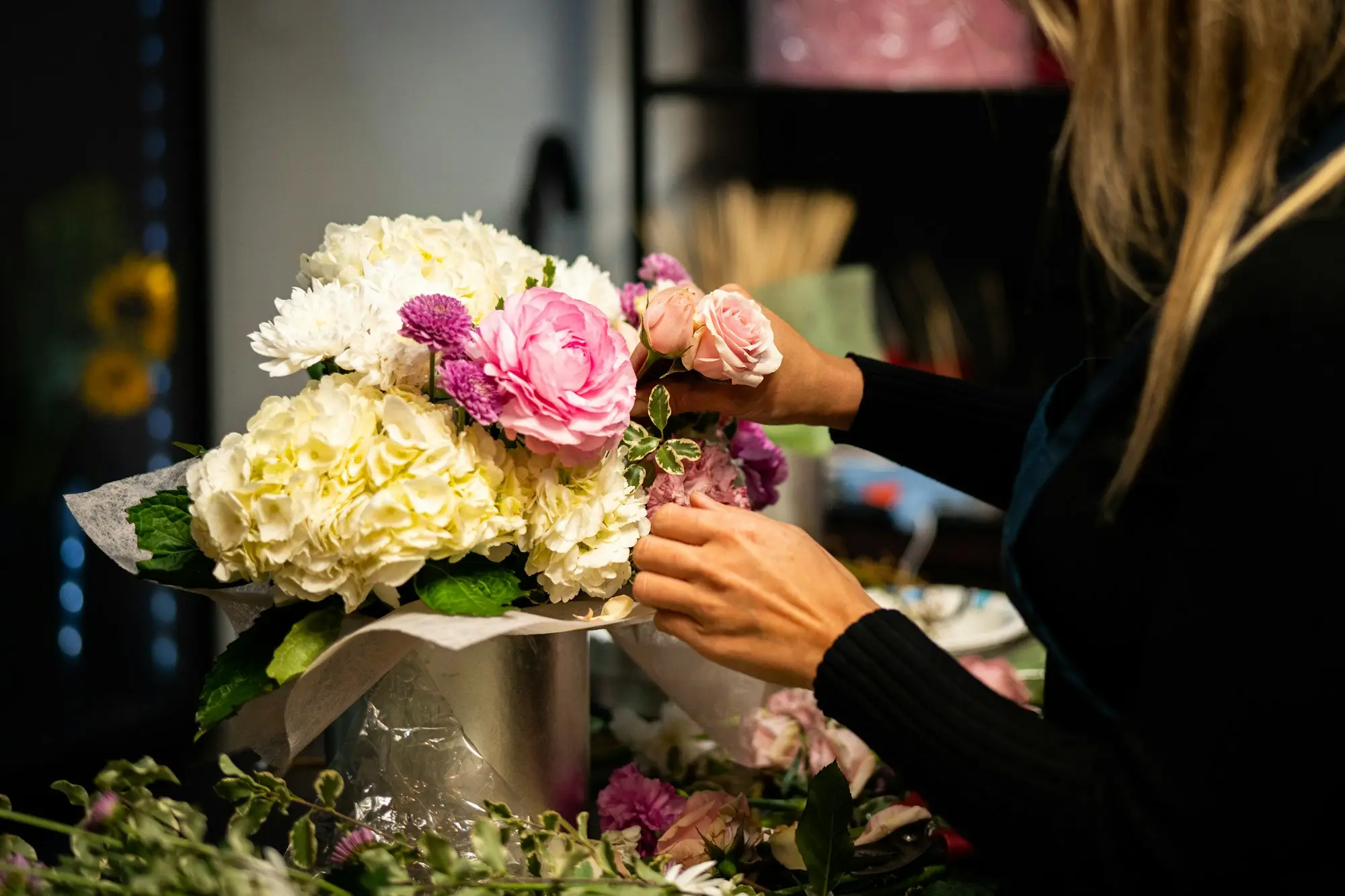 Florist arranging colourful bouquets in a small shop