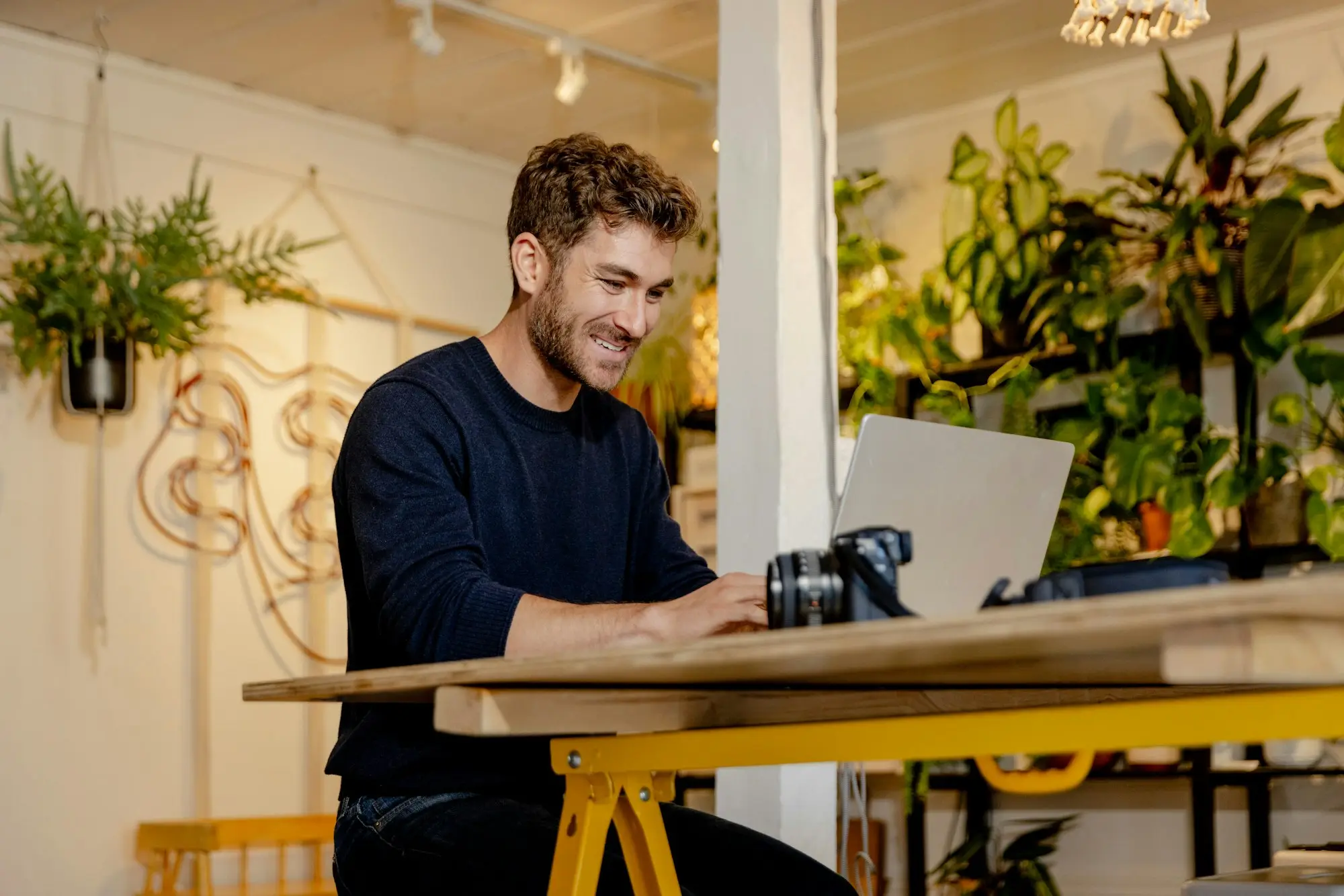Owner at a desk reviewing printed schedule and laptop