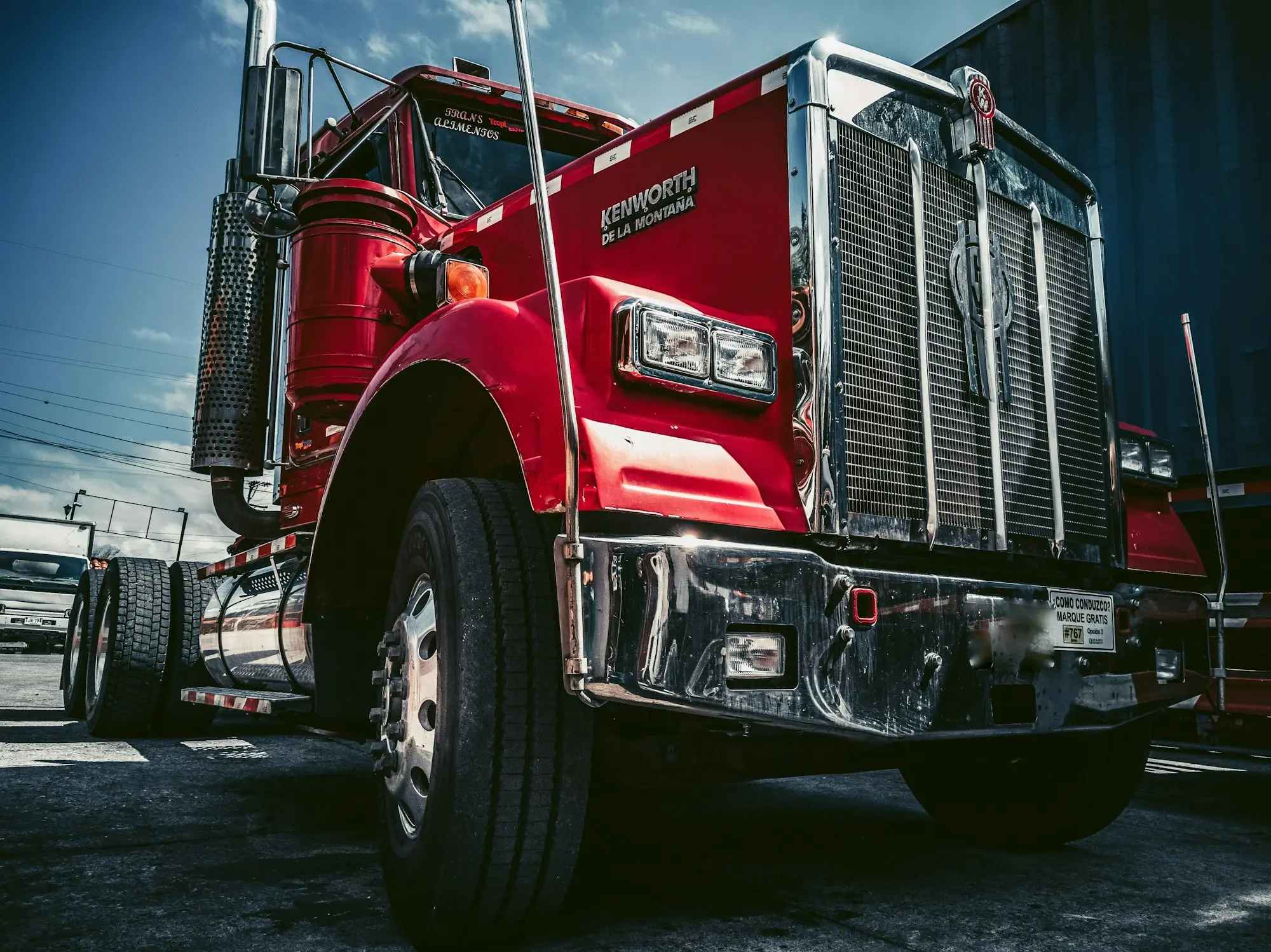Truck driver beside a prime mover or rigid truck at a depot